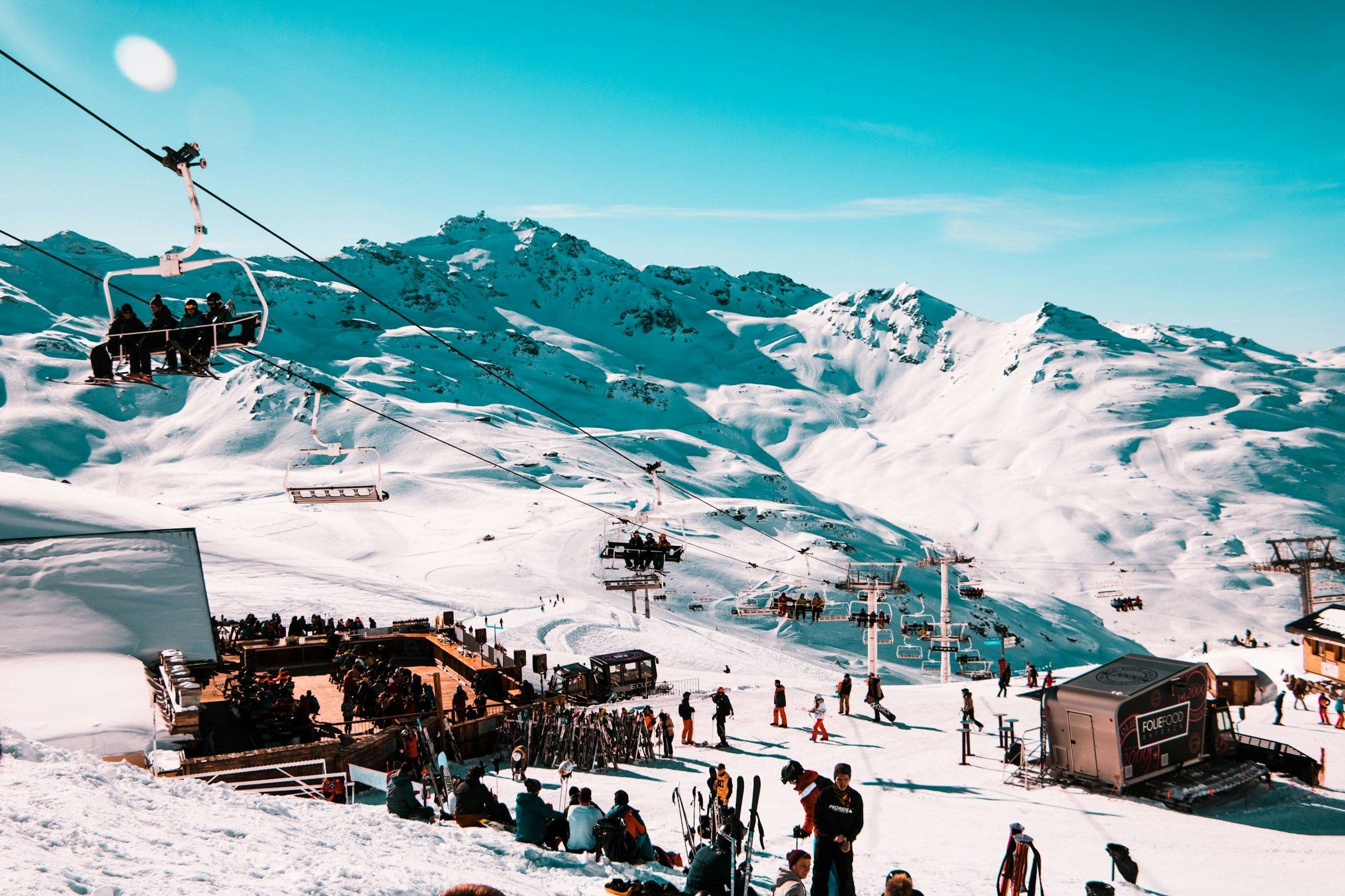 Skiers gathered on the terrace of a mountain restaurant beside the lifts and pistes at Val Thorens, France.