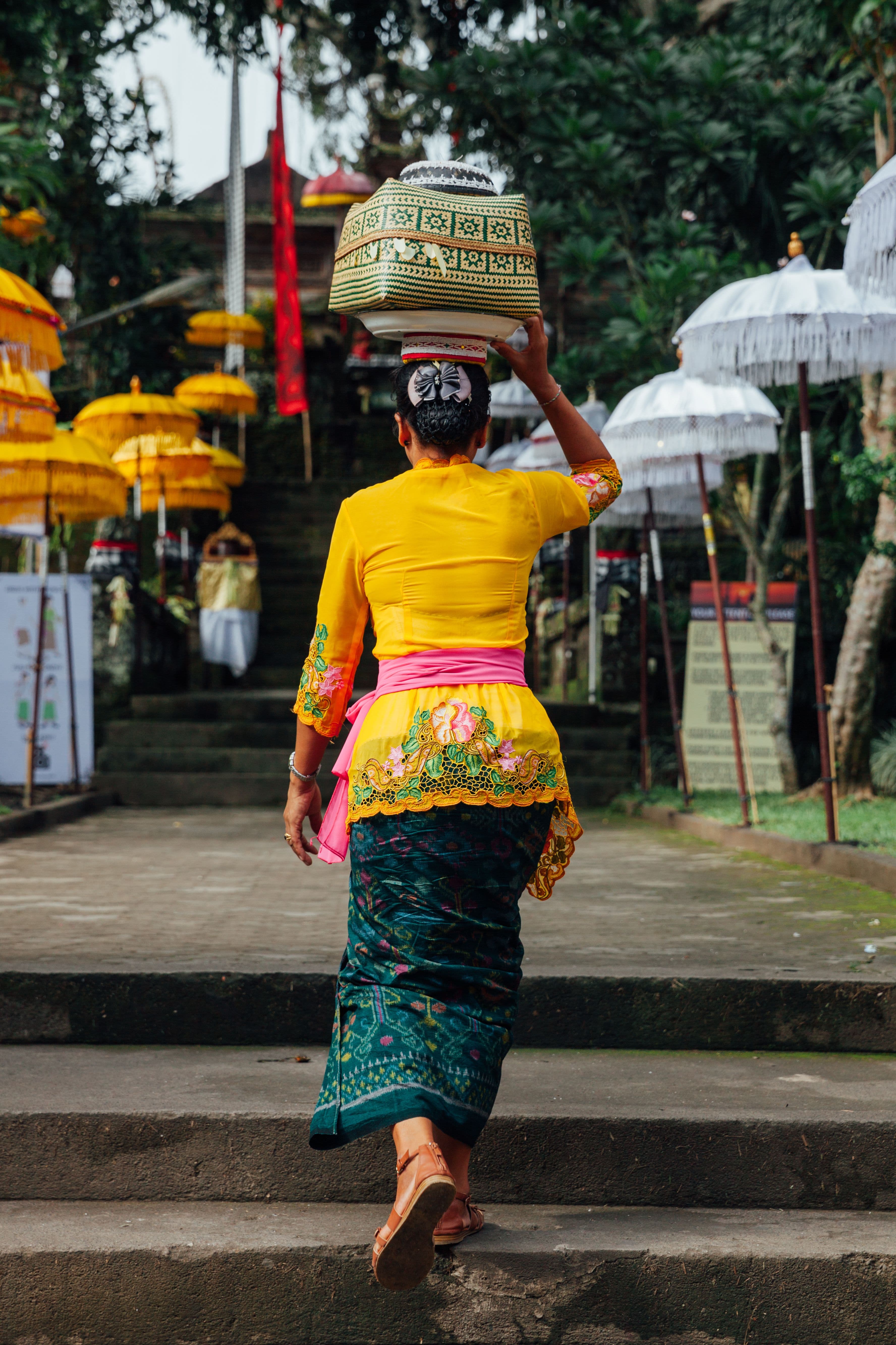 Woman Walks in Temple Grounds Carrying Basket
