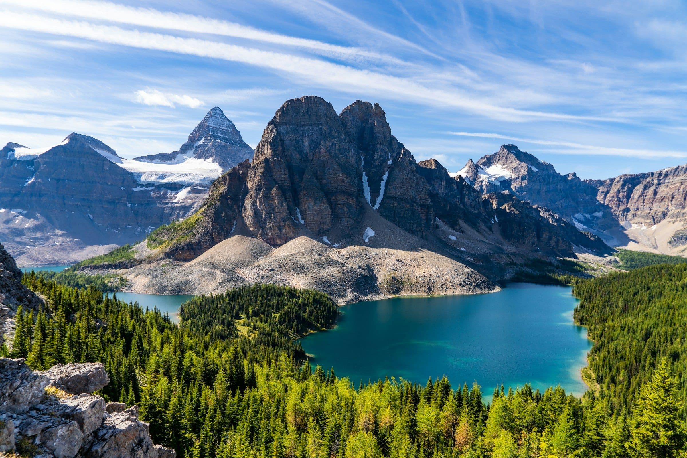 Mount Assiniboine above forest and turquoise lakes in the Canadian Rockies.