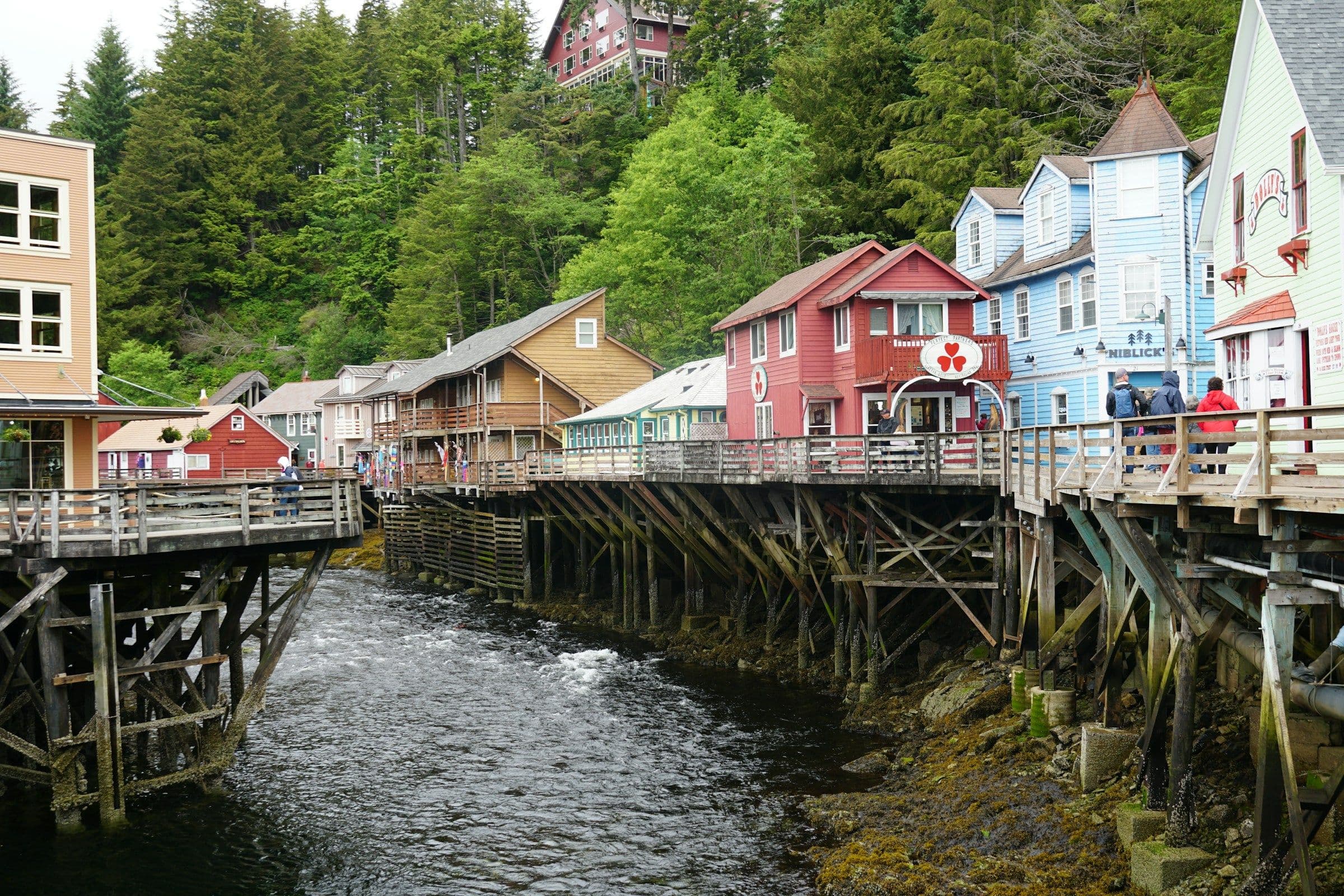 Painted wooden buildings on stilts above the creek at Creek Street in Ketchikan, Alaska.