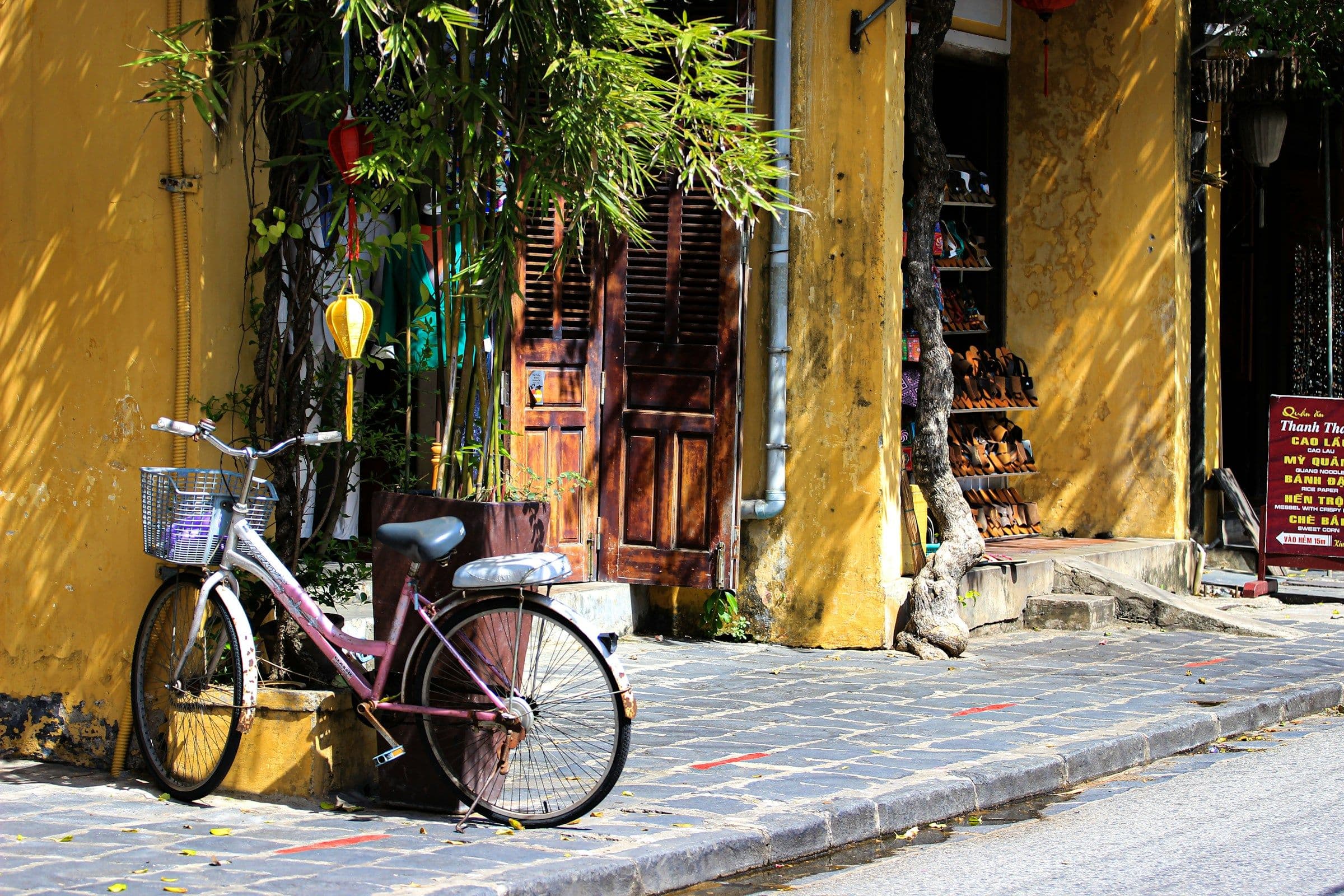 A bicycle leaning against an ochre-yellow wall in the old town of Hội An, Vietnam.