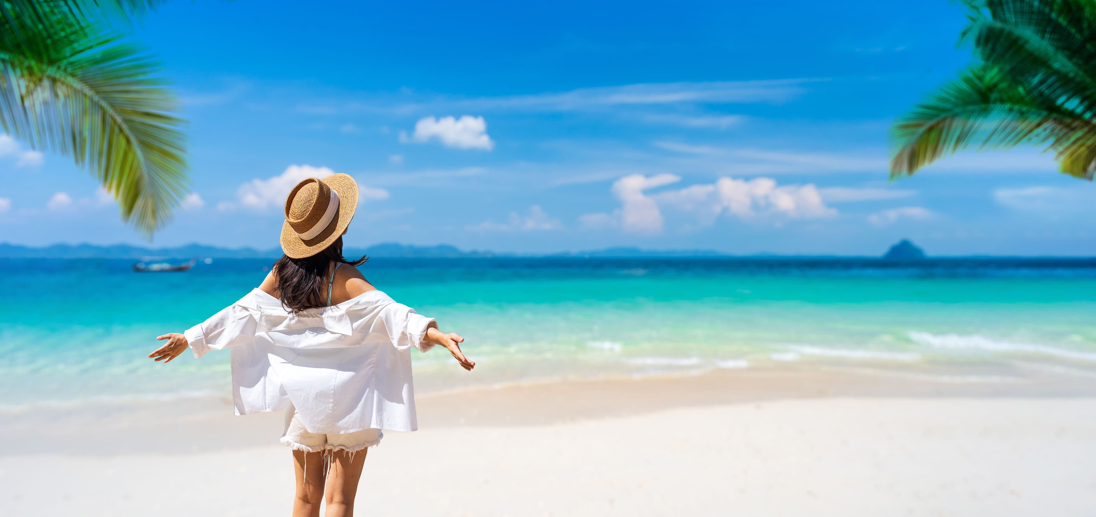 Young Woman with Open Arms Enjoying a Tropical Beach