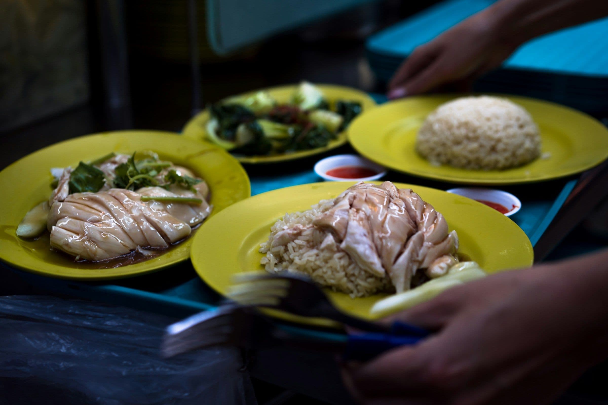 Plates of chicken rice being served at a stall in the Maxwell hawker centre, Singapore.