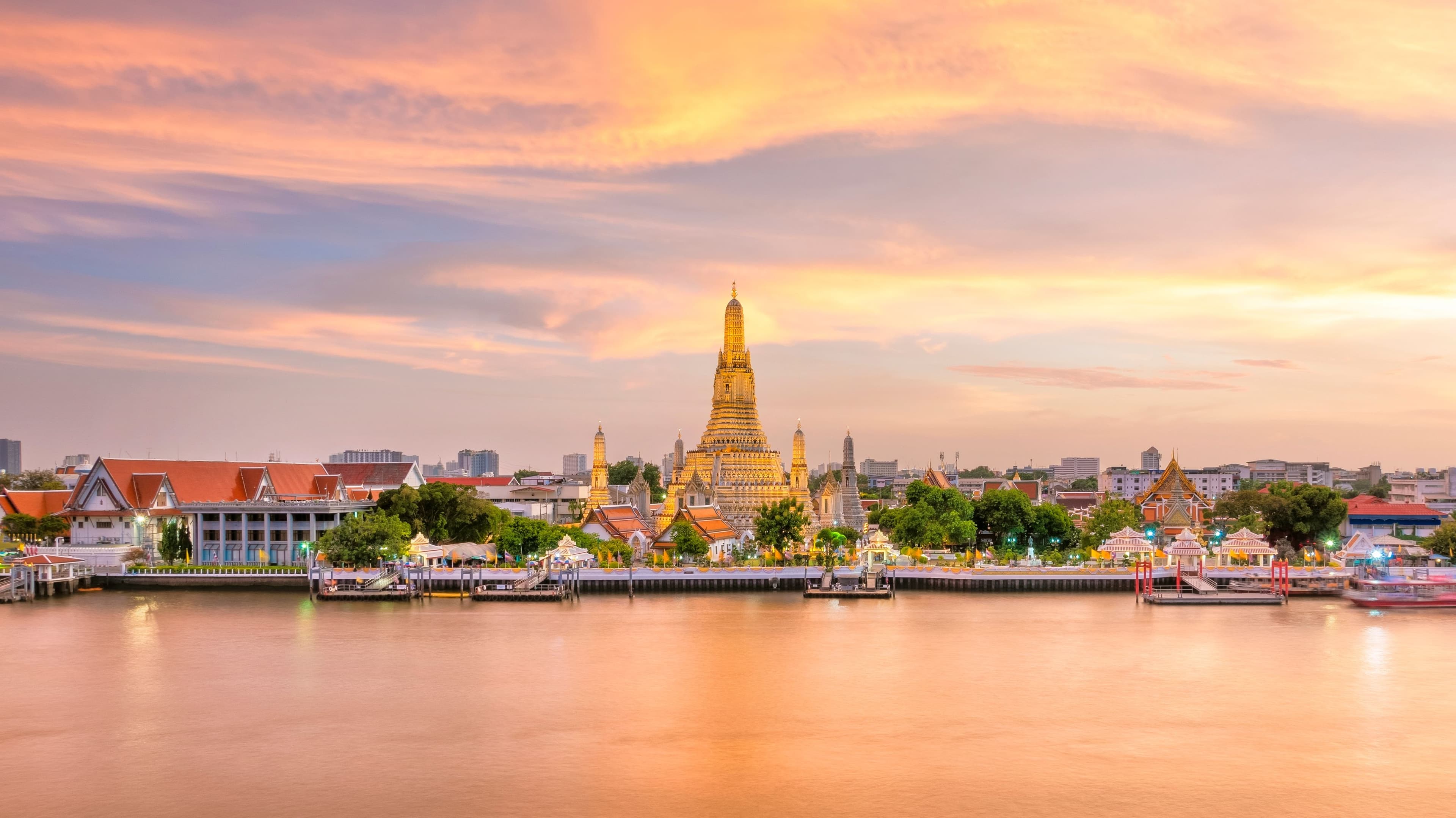 Ornate Temple along Calm River at Sunset