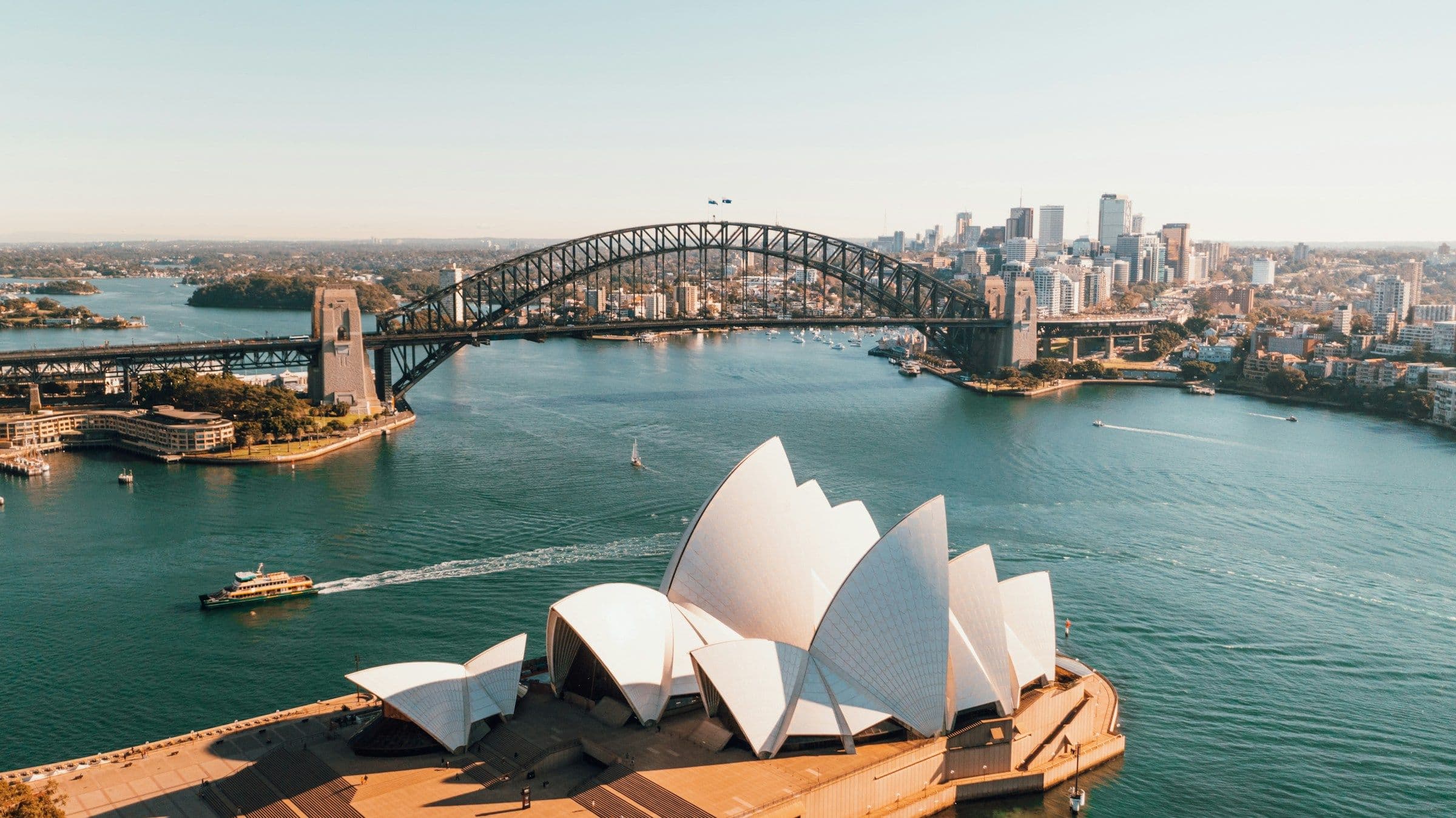 Sydney Harbour from the air, with the Opera House in the foreground and the Harbour Bridge beyond.